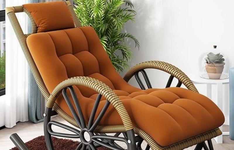 Người phụ nữ đang ngồi trên ghế thư giãn bập bênh đọc sách, gương mặt thể hiện sự thoải mái và thư thái